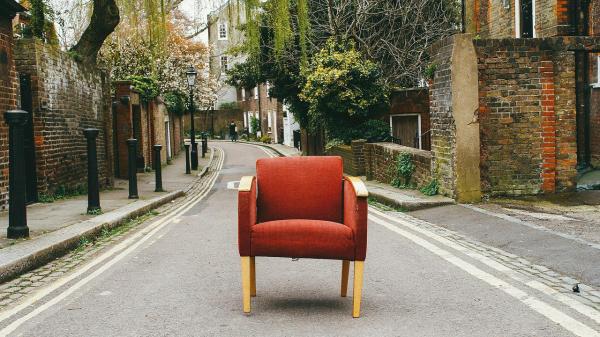 Roter Sessel auf kleiner Straße zwischen Häusern