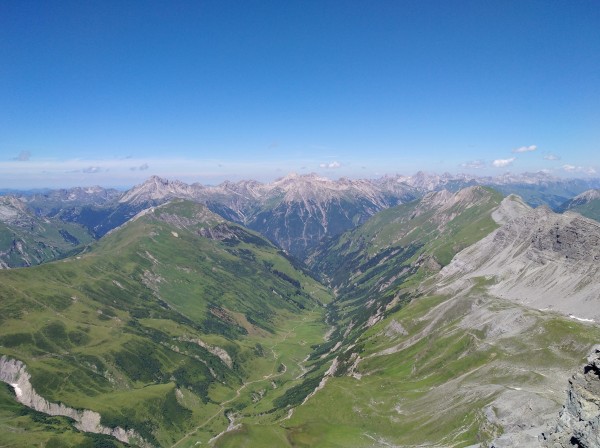 Blick von einem Berggipfel über die Alpen